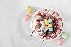 Easter bundt cake with chocolate nest of colorful candy eggs, overhead view
