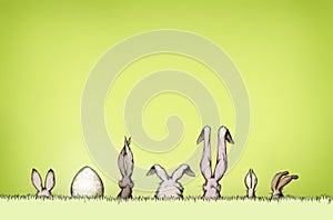 Easter bunnies with an Easter egg on a green meadow