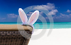 Easter bunny ears on sun chair at a tropical beach setting