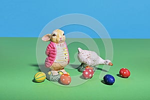 Easter bunny and a goose surrounded by colorful eggs