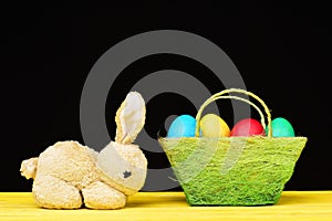 Easter bunny and green basket with colourful painted eggs