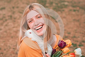 Easter Bunny. Little girl having fun on Easter egg hunt. Beautiful young woman with bunny rabbit on farm.