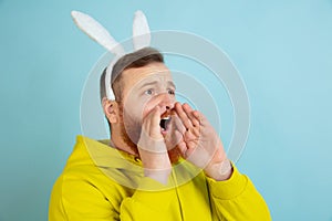 Easter bunny man with bright emotions on blue studio background