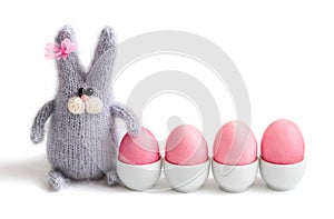 Easter bunny and painted pink eggs are isolated on a white background. Happy Easter concept. Space for text
