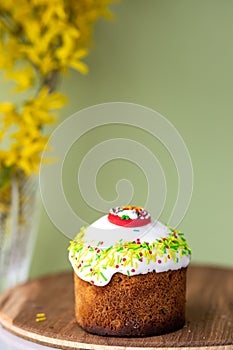 Easter cake with a bow on a yellow, light green background, and yellow spring flowers. Easter food. minimal concept