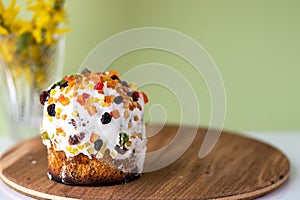 Easter cake with a bow on a yellow, light green background, and yellow spring flowers. Easter food. minimal concept