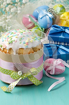 Easter cake, colored eggs and presents in blue boxes