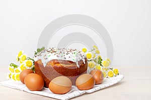 Easter cake and colored eggs  yellow flower blossoms on background. Holiday food and easter concept. Selective focus. Copyspase