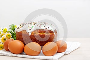 Easter cake and colored  eggs yellow flower blossoms on background. Holiday food and easter concept. Selective focus. Copyspase