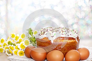 Easter cake and colored eggs  yellow flower blossoms on background. Holiday food and easter concept. Selective focus. Copyspase