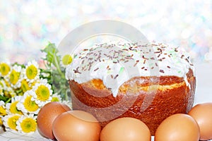 Easter cake and colored eggs yellow  flower blossoms on background. Holiday food and easter concept. Selective focus. Copyspase