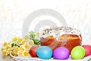 Easter cake and colored eggs yellow flower blossoms on background. Holiday food and easter concept. Selective focus. Copyspase