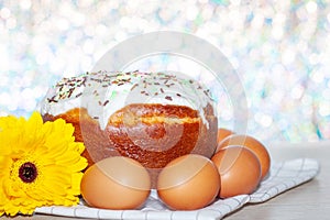 Easter cake and colored eggs yellow  flower blossoms on background. Holiday food and easter concept. Selective focus. Copyspase