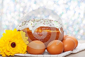 Easter cake and colored eggs yellow flower blossoms on background. Holiday food and easter concept. Selective focus. Copyspase