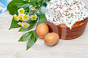Easter cake and colored eggs yellow flower  blossoms on background. Holiday food and easter concept. Selective focus. Copyspase