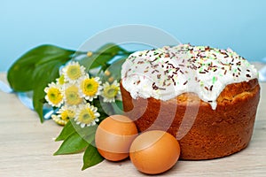 Easter cake and colored eggs yellow flower  blossoms on background. Holiday food and easter concept. Selective focus. Copyspase