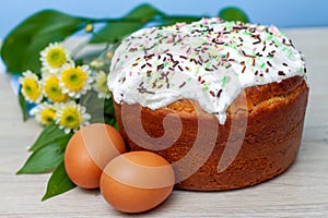 Easter cake and colored eggs yellow flower  blossoms on background. Holiday food and easter concept. Selective focus. Copyspase