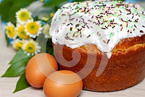 Easter cake and colored eggs yellow flower blossoms on background. Holiday food and easter concept. Selective focus. Copyspase