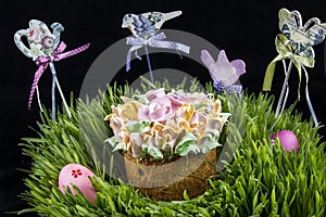 Easter cake and colorful eggs in green grass