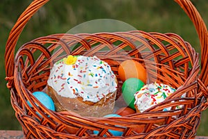 Easter cake and colorful Easter eggs in wicker basket