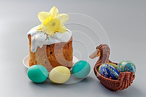 Easter cake and colorful Easter eggs in wicker basket