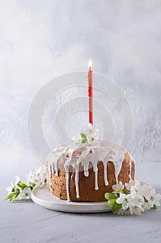 Easter cake decorated spring fresh flowers and traditional red candle.