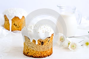 Easter cake decorated with white sugar icing and confectionery powder with a bouquet of flowers on a white background