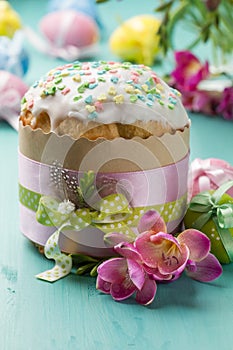 Easter cake, flowers and eggs on a turquoise table