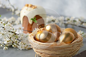 Easter cake and golden eggs on table