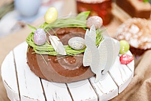Easter cake orthodox sweet bread kulich and colorful chocolate eggs on festive table