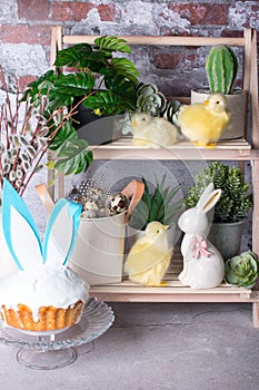 Easter cake on a plate, painted eggs with willow branches and an Easter bunny.