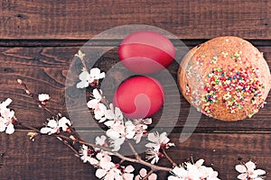 Easter cake and red eggs on rustic wooden table. Top view