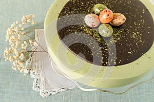 Easter cake with tea match decorated chocolate ganache and sweet-stuff eggs