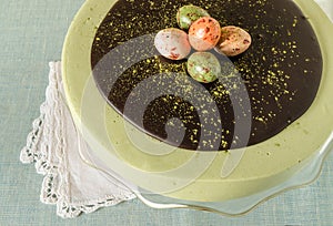 Easter cake with tea matcha decorated chocolate ganache and sweet-stuff eggs