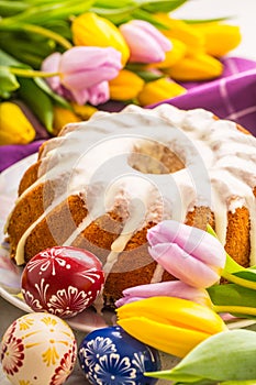 Easter Cake. Traditional ring marble cake withe easter decotation. Easter eggs and spring tulips.