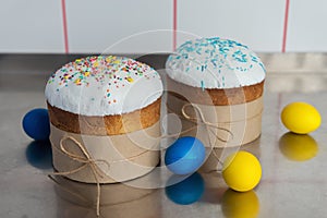 Easter cake with a white top, decorated with multi-colored sprinkles and Easter eggs on kitchen table