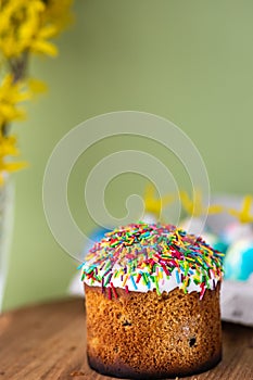 Easter cake on a yellow, light green background and yellow spring flowers. easter colored eggs. Easter food. minimal