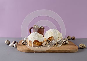 easter cakes covered with white glaze quail eggs on a wooden cutting board side view easter still life