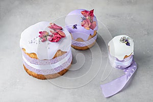 Easter cakes of different sizes decorated by lavender ribbons and colourful and modern dry flowers