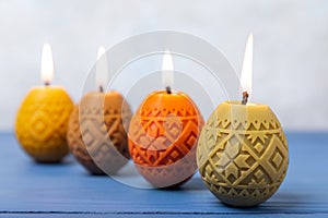 Easter candle eggs and willow branches on textural background.