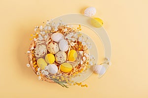 Easter candy chocolate eggs and almond sweets lying in a bird's nest