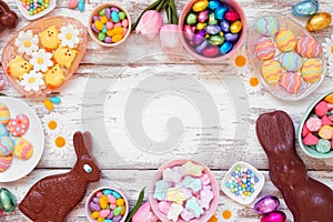 Easter candy frame over a white wood background