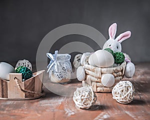 Easter card, a basket with a figurine of a rabbit with eggs, straw decorative balls