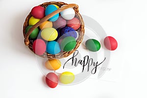 Easter card with colorful Easter eggs in a basket and calligraphic inscription `Happy Easter`