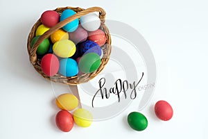Easter card with colorful Easter eggs in a basket and calligraphic inscription `Happy Easter`