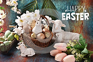 Easter card with a wicker basket full of eggs, bunny and lamb figurines and flowers