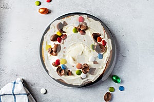 Easter carrot cake with cream cheese, sweet candies and chocolate. Top view. Homemade festive baking