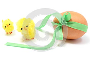 Easter chickens and egg with green ribbon. White background