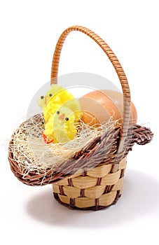 Easter chickens in wicker basket and fresh egg