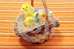 Easter chickens in wicker basket and painted egg